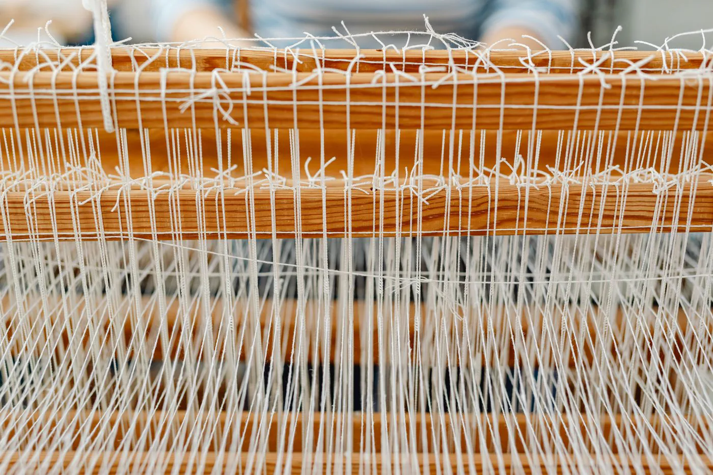Wooden loom with white threads